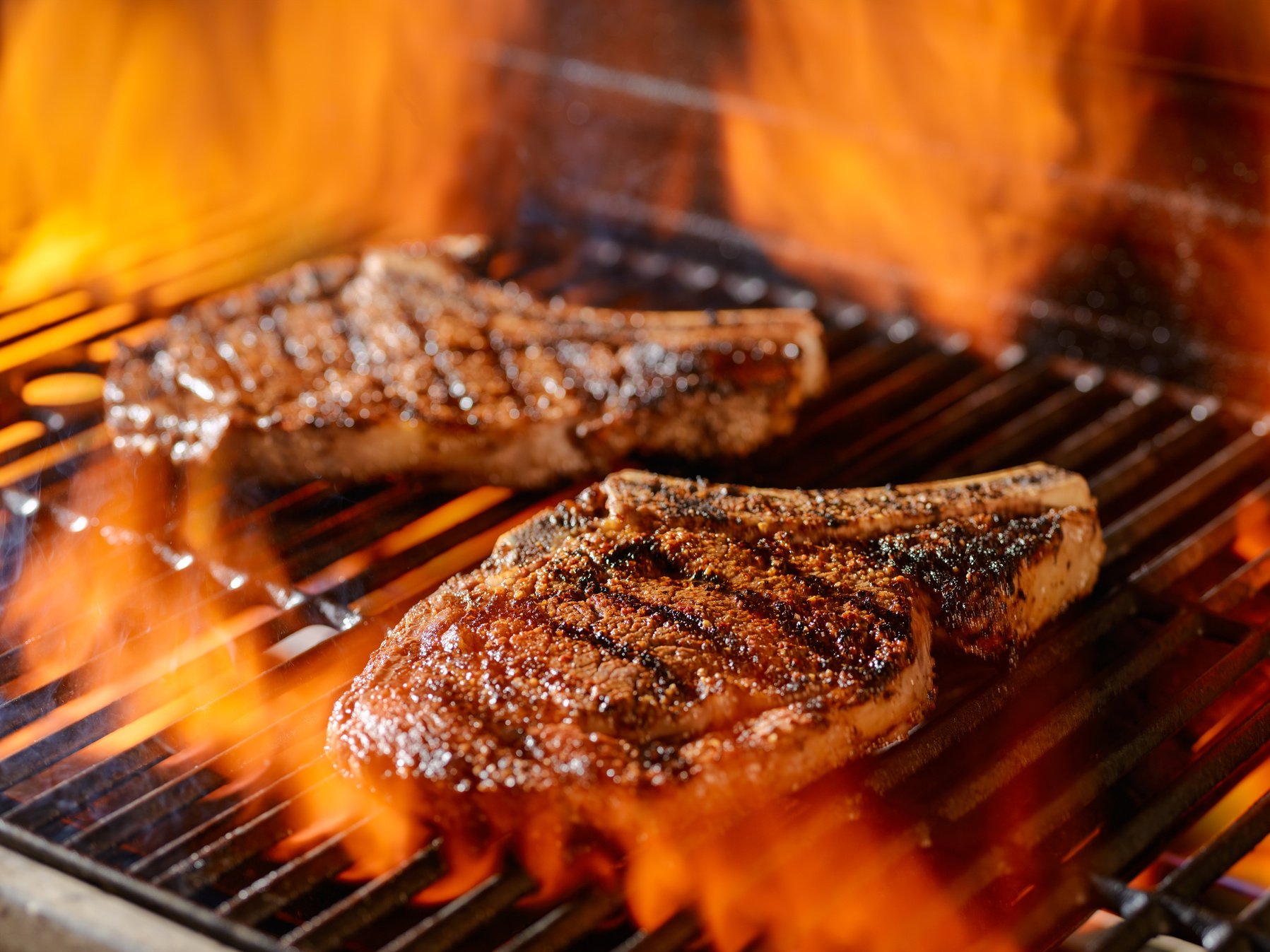 Two Ribeye Steaks Grilling on the Open Flame